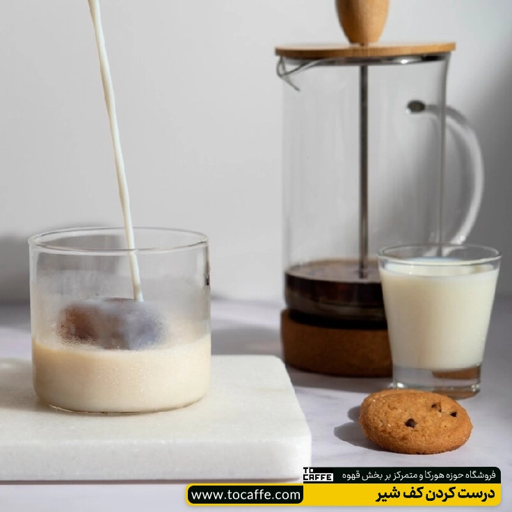یک فرنچ پرس حاوی مقداری قهوه در کنار یک فنجان شیر قرار گرفته