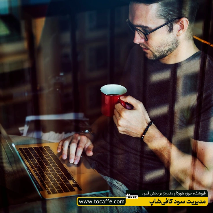 فردی در حال محاسبه درآمد کافی‌شاپ است