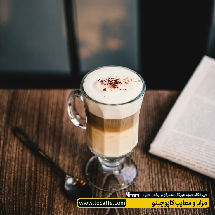 یک لیوان کاپوچینو روی یک میز قهوه‌ای رنگ قرار گرفته است