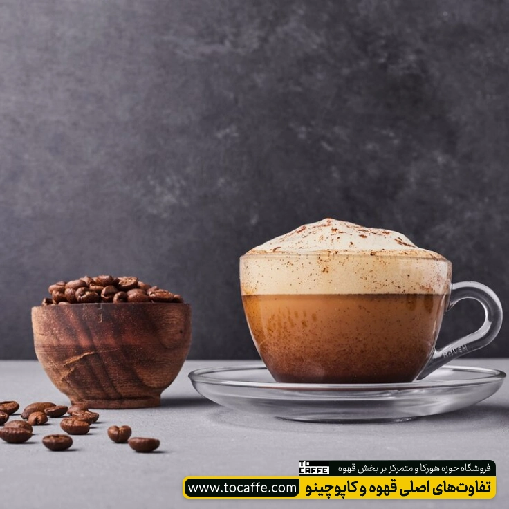 یک فنچان کاپوچینو که در کنار آن پیاله‌ای پر از دان قهوه قرار گرفته است.
