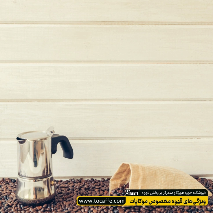یک دستگاه موکاپات روی انبوهی از دانه‌های قهوه قرار گرفته است